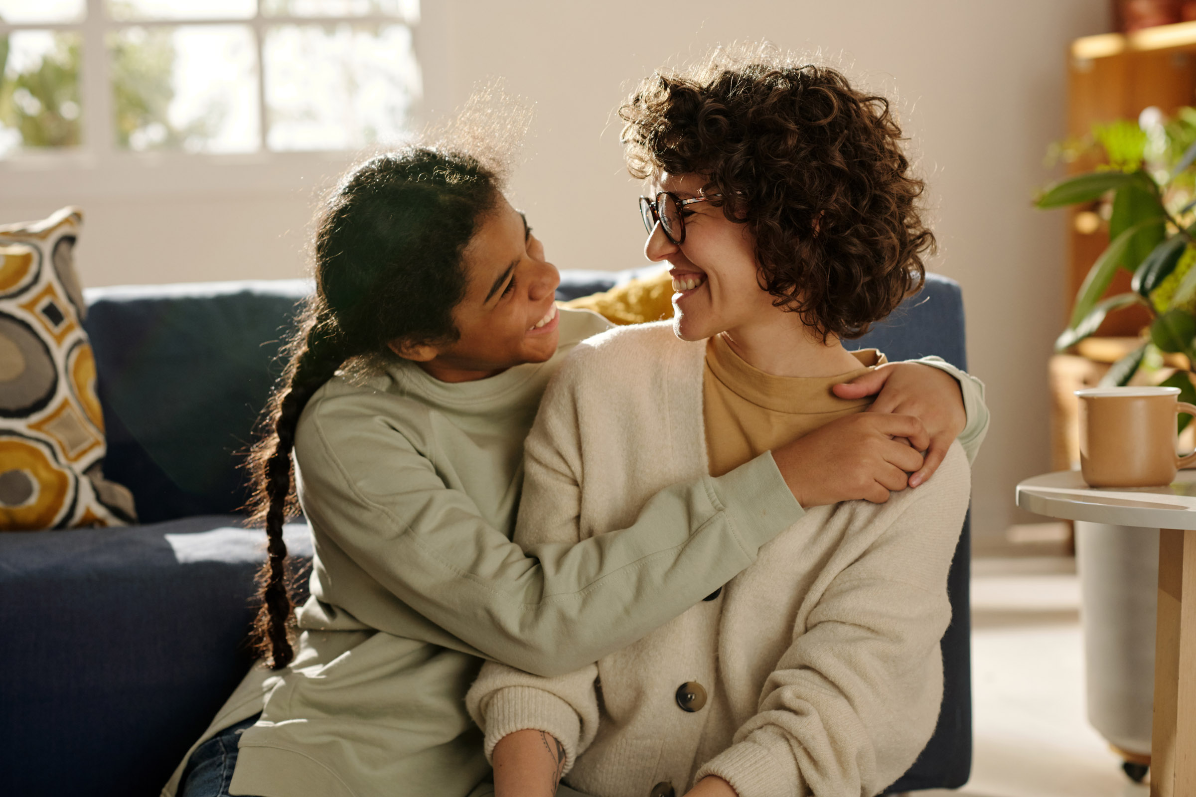 mother and daughter hugging on couch