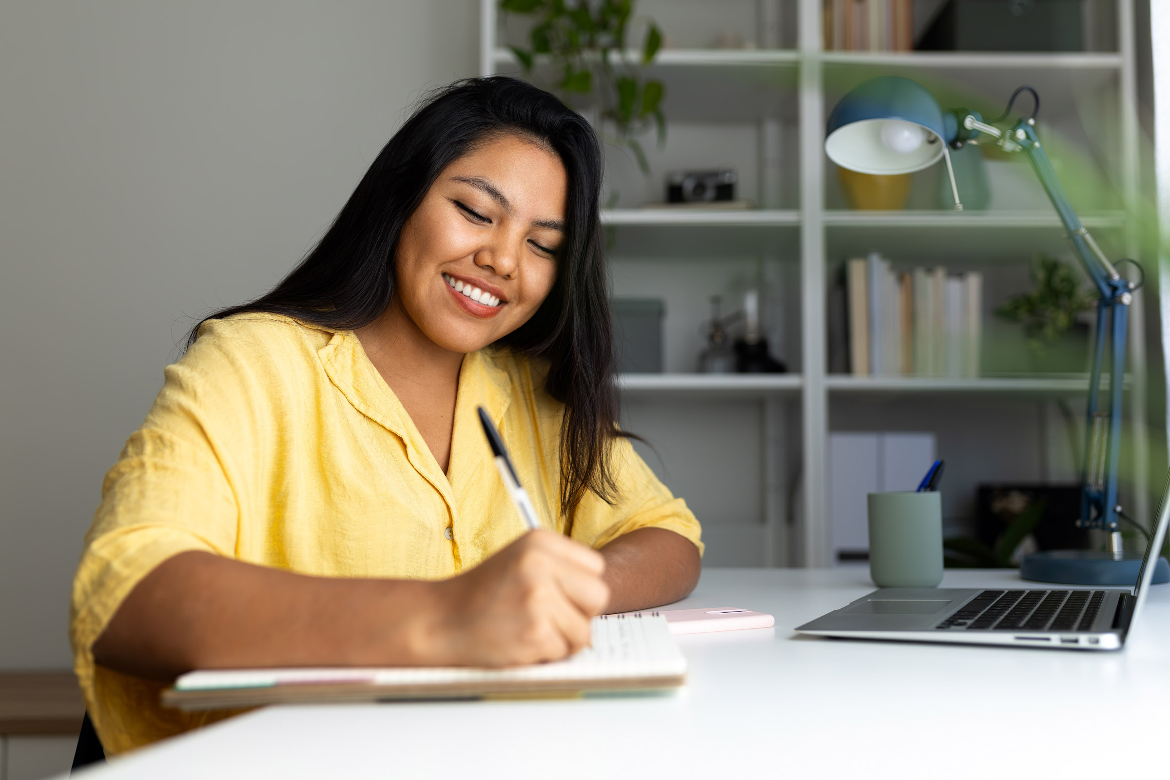 woman writing notes at desk
