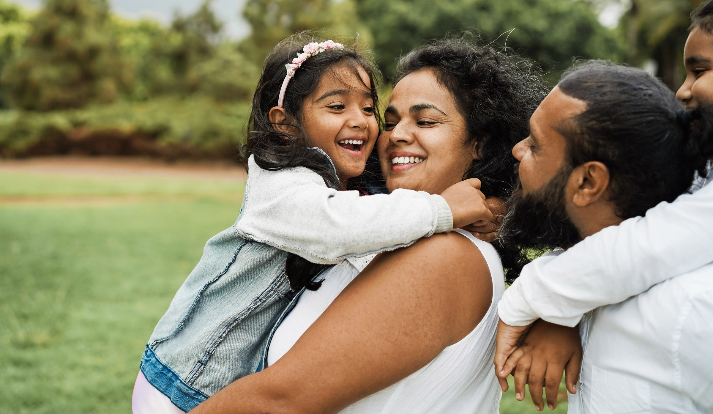 family group hug outdoors in park