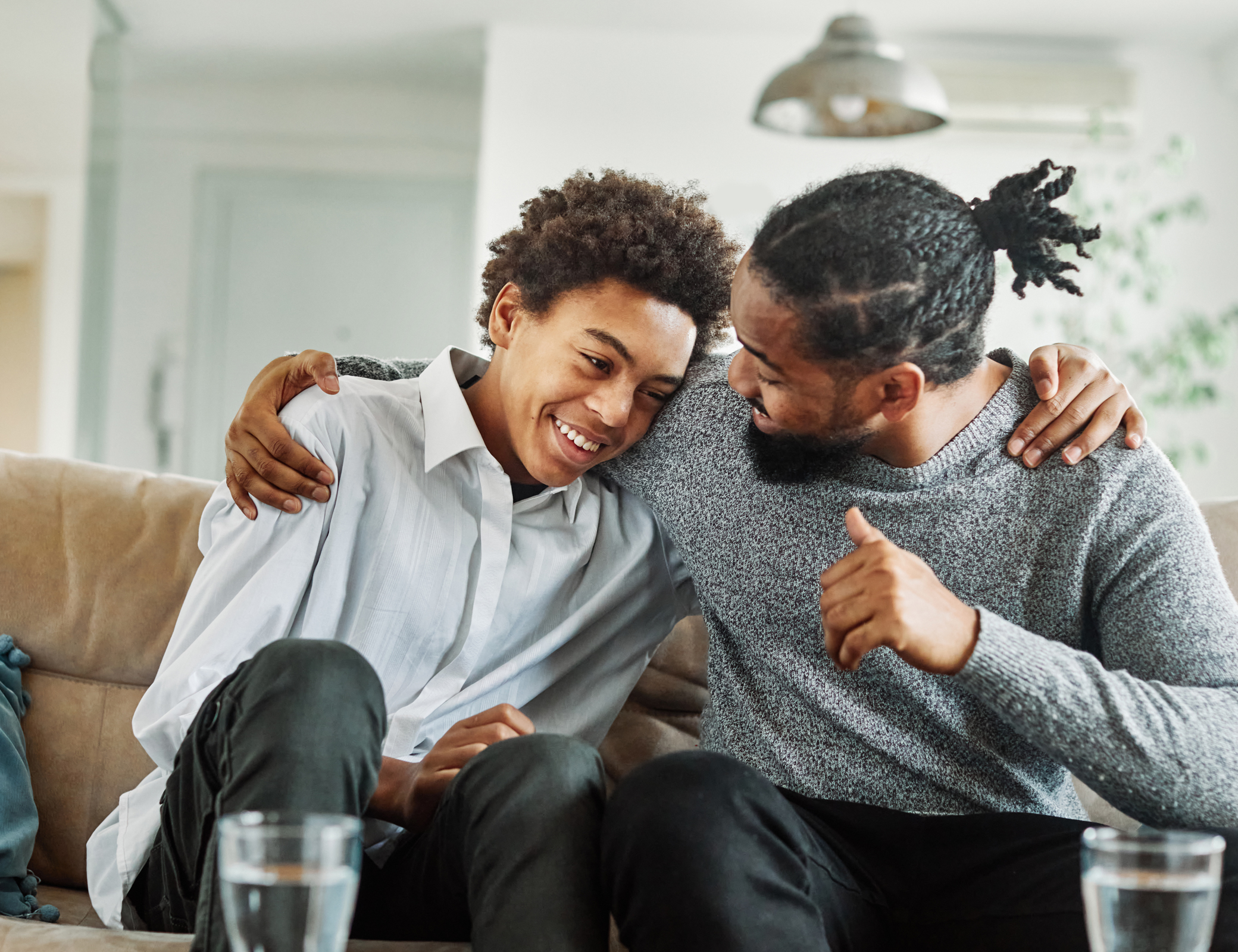 smiling teen and man hugging couch